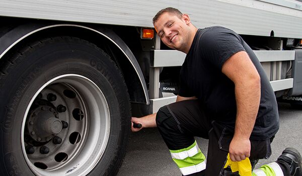 En man som arbetar på en lastbils däck.