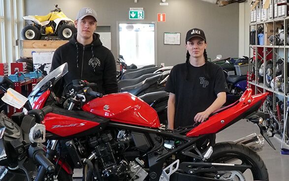 Elever och MC Två elever står bakom en MC