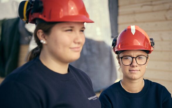 BA-tva-elever-587×367 Två unga kvinnor som bär hårda hattar.